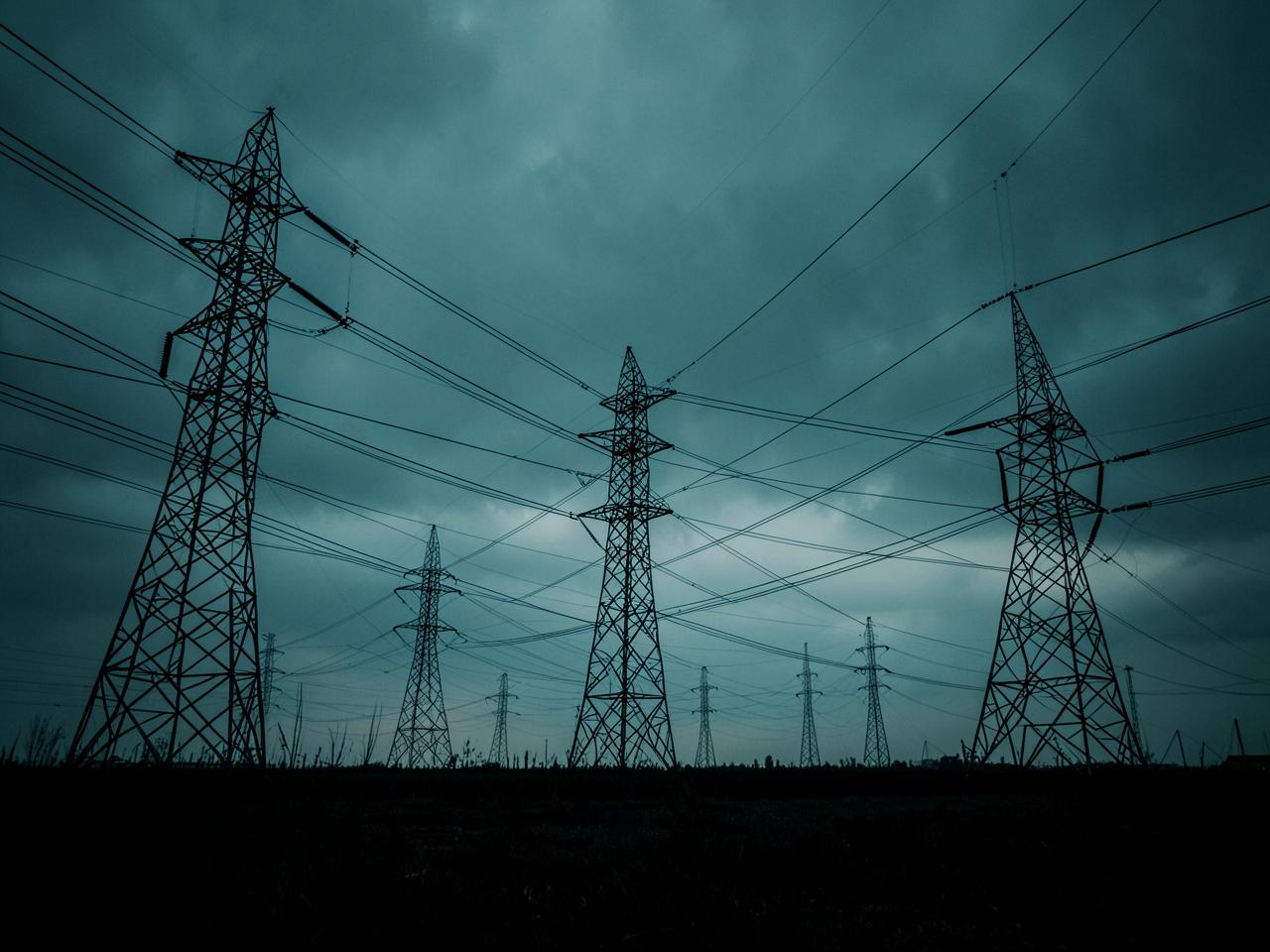 High-voltage transmission towers against an overcast sky